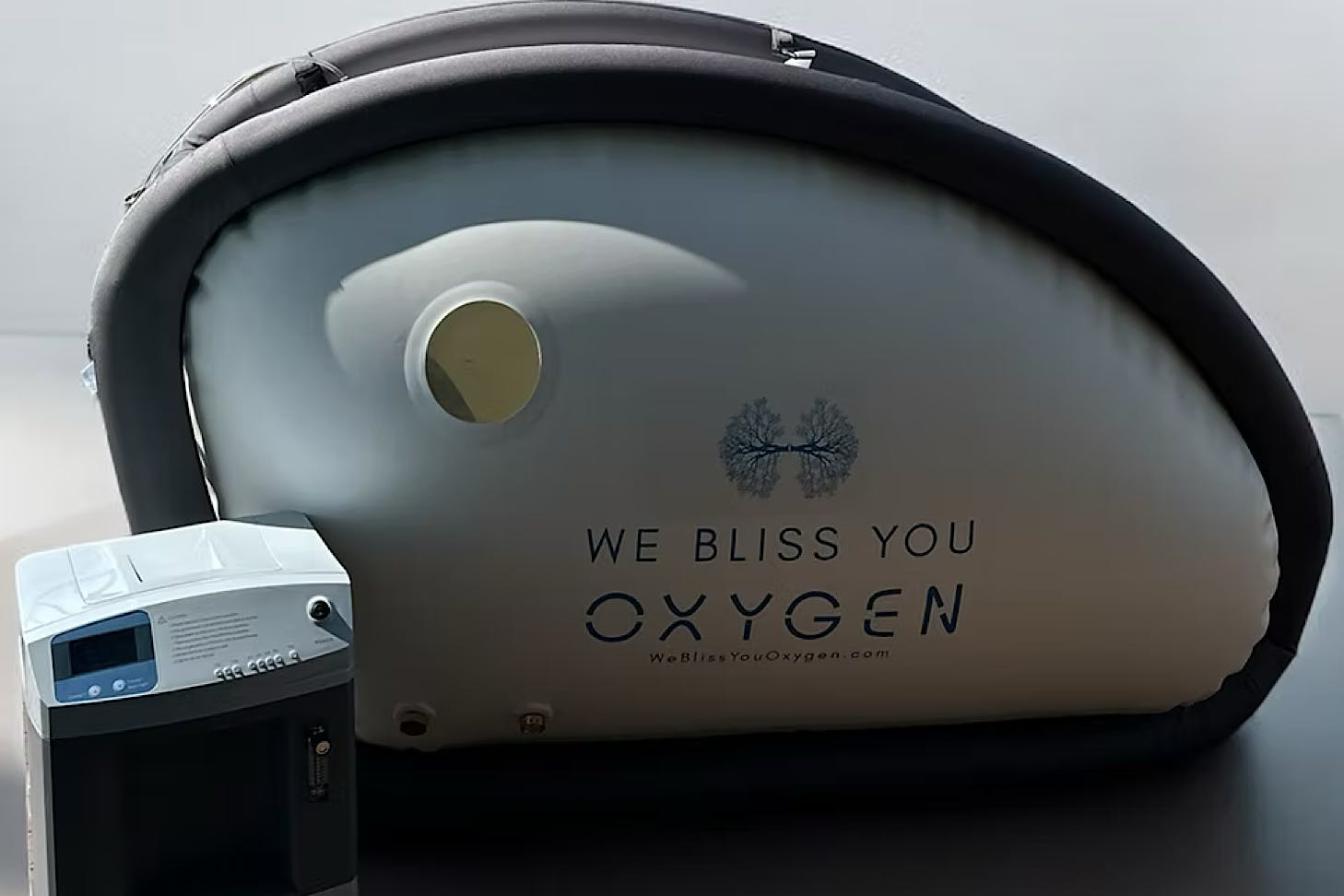 An inflatable hyperbaric oxygen chamber printed with the words 'we bliss you oxygen.'